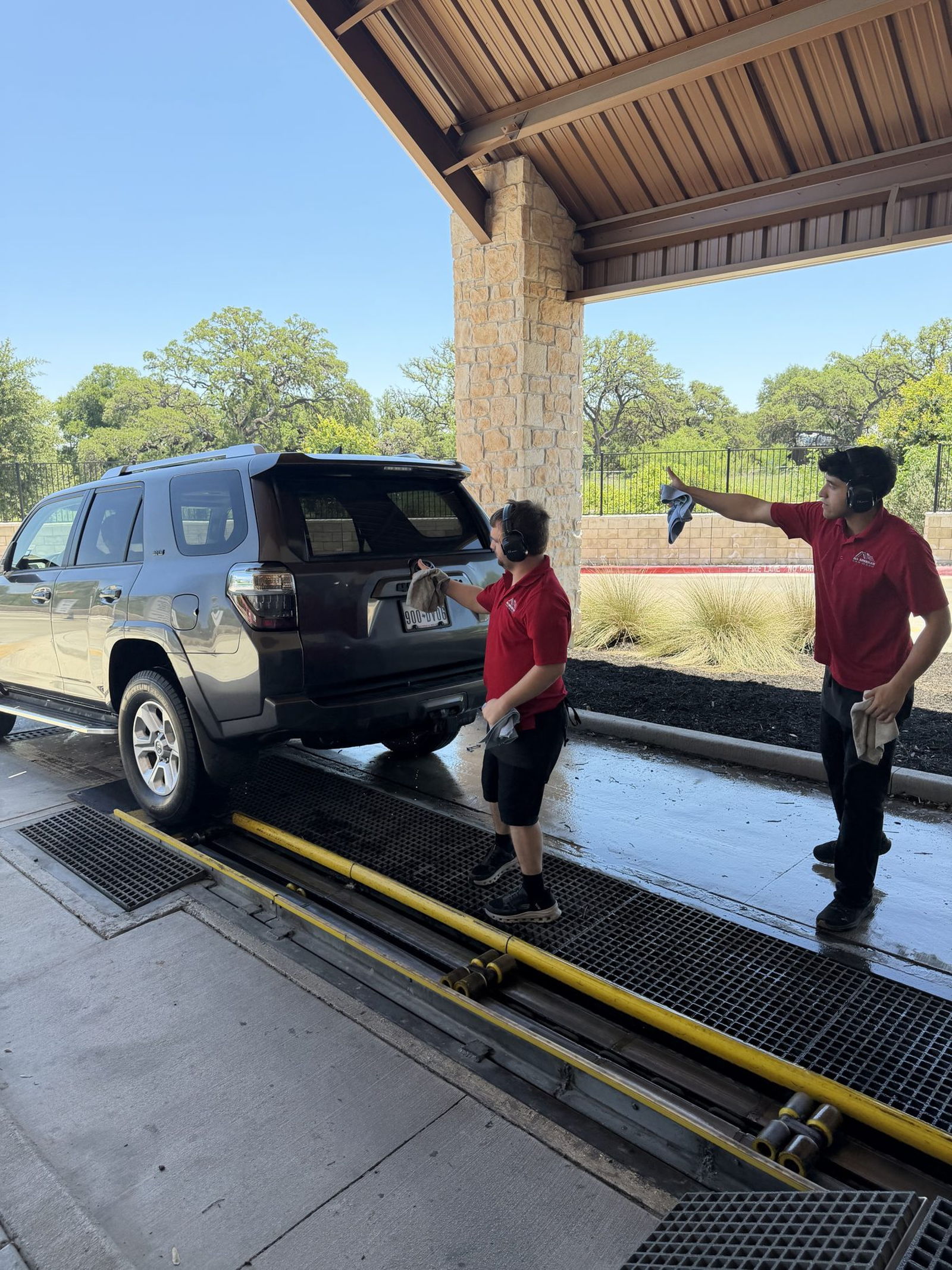 All American wash professionals hand-drying a vehicle at the exit