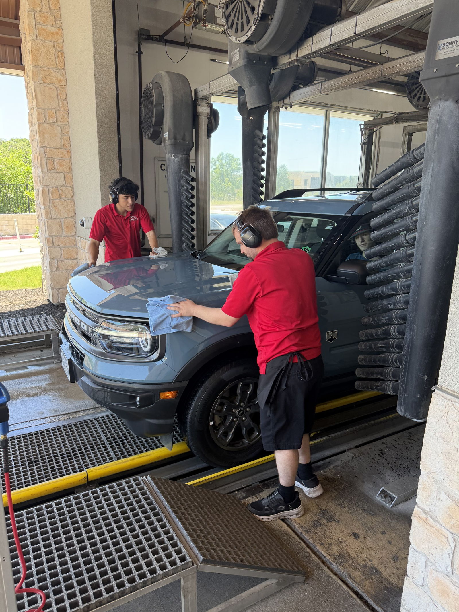 An All American attendant hand towel-drying a vehicle in the tunnel